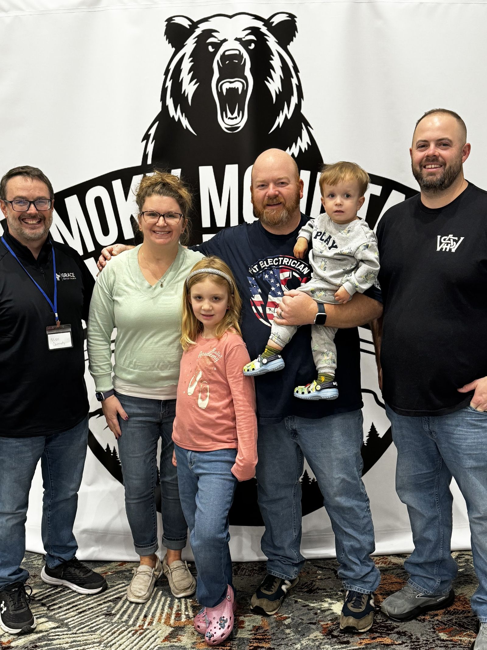 A family posing at the Wash Retreat photo wall